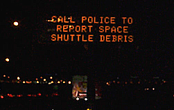 Highway sign: CALL POLICE TO REPORT SPACE SHUTTLE DEBRIS